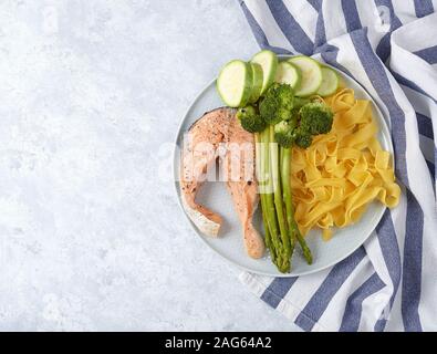 Gesundes Essen, gedünsteter Lachs mit gedünstetem Gemüse. Auberginen, Brokkoli, Spargel. Ansicht von oben Stockfoto