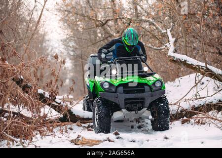 Fahrer fahren in den Quad Rennen im Winter im Wald Stockfoto