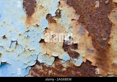 Nahaufnahme von rostfreiem Stahl, wo blaue Farbe abblättet. Stockfoto