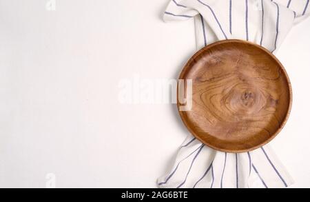 Die braune hölzerne Platte auf einem Handtuch, auf blauen Tabelle, Ansicht von oben Stockfoto