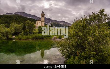 Die alte Pfarrkirche St. Gertraud Spiegelung im See, das Ortlergebiet mit dem Gipfel des Ortler in der Ferne Stockfoto