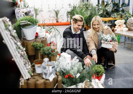 Junger Mann mit Frau shopping präsentiert in Store in der Zeit vor dem Winterurlaub. Schönes Paar kauft Geschenke für Familie und Freunde Stockfoto