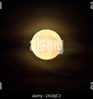 Vollmond/Vollmond scheint in dunkler Nacht, Amber Mond mit einigen wenigen geschwollene, trübe Wolken. Stockfoto