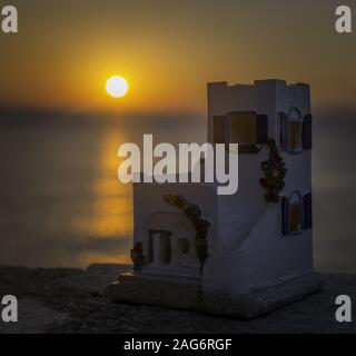 Nahaufnahme einer weißen Schlossfigur am Strand Mit dem schönen Sonnenuntergang im Hintergrund Stockfoto