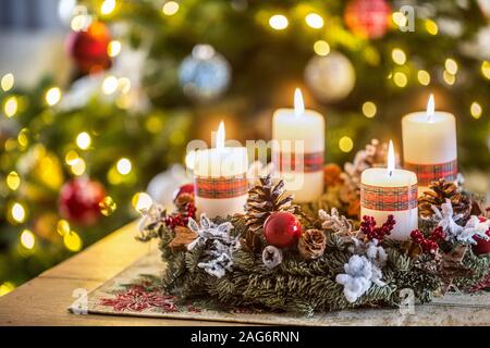 Adventskranz mit vier weißen brennende Kerzen christmas ball und Dekorationen auf einer hölzernen Hintergrund mit Festliche Atmosphäre Stockfoto
