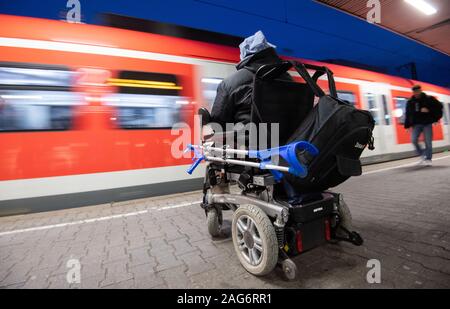 Ludwigsburg, Deutschland. 17 Dez, 2019. Steffen Gödecke steht mit seinen elektrischen Rollstuhl auf einem Bahnhof auf einer Spur. Credit: Marijan Murat/dpa/Alamy leben Nachrichten Stockfoto