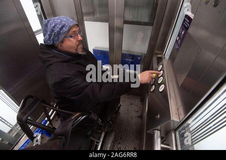 Ludwigsburg, Deutschland. 17 Dez, 2019. Steffen Gödecke Laufwerke in einem Aufzug mit seinen elektrischen Rollstuhl in der Station. Credit: Marijan Murat/dpa/Alamy leben Nachrichten Stockfoto