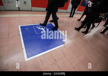 Stuttgart, Deutschland. 17 Dez, 2019. Menschen gehen in einer S-Bahn-Station am Hauptbahnhof über eine Markierung für Rollstuhlfahrer. Credit: Marijan Murat/dpa/Alamy leben Nachrichten Stockfoto