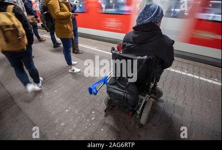 Ludwigsburg, Deutschland. 17 Dez, 2019. Steffen Gödecke steht mit seinen elektrischen Rollstuhl auf einem Bahnhof auf einer Spur. Credit: Marijan Murat/dpa/Alamy leben Nachrichten Stockfoto