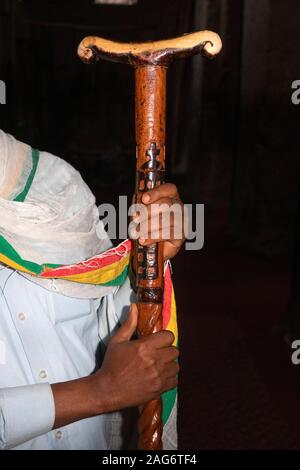 Äthiopien, Amhara, Lalibela, alte Felsen geschnitten Kirchen, innen Wette Medhane Alem Kirche, Hände, die großen traditionellen Gebet stick Stockfoto