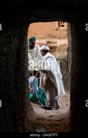 Äthiopien, Amhara, Lalibela, alte Felsen geschnitten Kirchen, Priester am Ende des Rock tunnel Segen geistesgestörten Frau Stockfoto