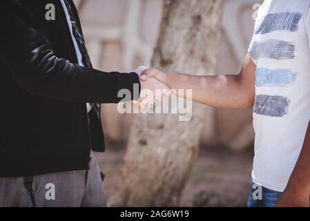 Nahaufnahme von zwei Männchen, die Hand mit einem verschwommenen schütteln Hintergrund Stockfoto
