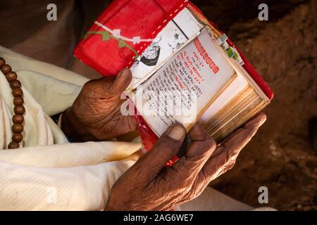 Äthiopien, Amhara-region, Lalibela, Wette Maryam Kirche Hof, Hände von devotee Lesung Evangelium in Amharisch text Stockfoto