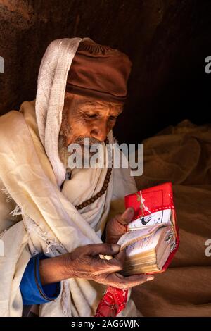 Äthiopien, Amhara-region, Lalibela, Wette Maryam Kirche, devotee Lesung Evangelium in Amharisch text Stockfoto