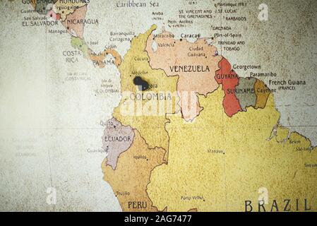 Nahaufnahme einer schwarzen Nadel auf dem kolumbianischen Land Auf der Karte Stockfoto