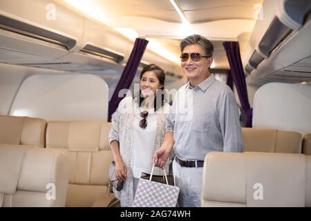 Reifes chinesisches Paar im Flugzeug Stockfoto