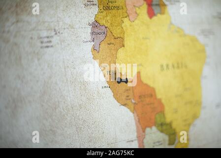 Selektive Fokusaufnahme einer schwarzen Nadel auf Peru Land Auf der Karte Stockfoto