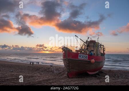 Hastings, East Sussex, UK. Dezember 2019 18. Bunte sunrise auf dem Stade für Menschen zu Fuß am Strand an einem sonnigen Tag in Hastings. Carolyn Clarke/Alamy leben Nachrichten Stockfoto