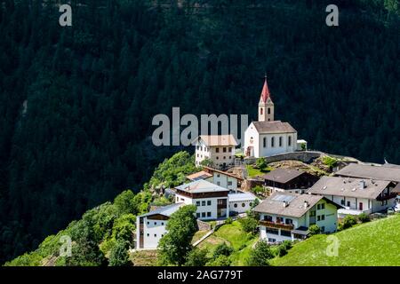 Die alte Pfarrkirche St. Katharina und die Häuser des Dorfes Katharinaberg, Monte Santa Caterina, an einem Berghang oberhalb des Tals Schnalstal Stockfoto