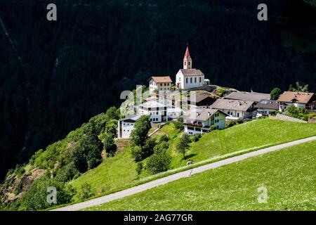 Die alte Pfarrkirche St. Katharina und die Häuser des Dorfes Katharinaberg, Monte Santa Caterina, an einem Berghang oberhalb des Tals Schnalstal Stockfoto