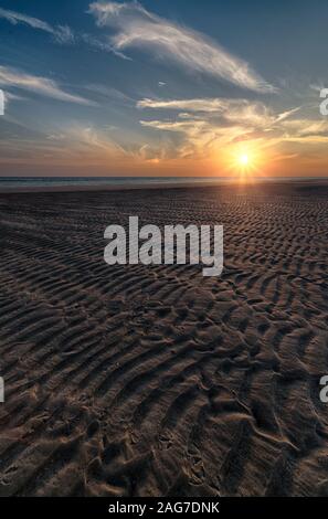 Vertikale Aufnahme eines schönen Sonnenaufgangs am Strand erstellen Die perfekte Kulisse für Morgenspaziergänge Stockfoto