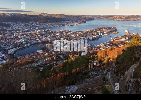 Bergen City und nördlichen fjord Blick vom Mount Floyen im Herbst frostigen Morgen. Earky Sonneneinstrahlung auf Gebäude unten. Schienen der Standseilbahn der Rechten Stockfoto