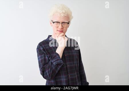 Junge albino blonder Mann legere Shirt und Brille über isoliert weißer Hintergrund schaut zuversichtlich in die Kamera mit einem Lächeln mit verschränkten Armen ein Stockfoto