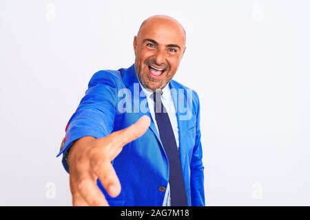 Mittleres Alter Geschäftsmann tragen Klage über isoliert weißer Hintergrund lächelt freundlich mit Handshake als Ansage und einladend. Erfolgreiche Stockfoto
