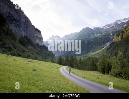 High-Angle-Aufnahme eines männlichen Schlittschuhlaufers auf der Straße In den Bergen an einem kalten Tag Stockfoto