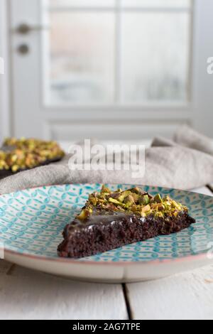 Vertikale Hochwinkel Schuss einer leckeren Schokoladenkuchen mit Verschiedene Arten von Nüssen auf der Oberseite Stockfoto