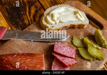Eine geräucherte Wurst Sandwich. Scheiben Salami, Gurken und Knäckebrot mit weißer Soße. Stockfoto