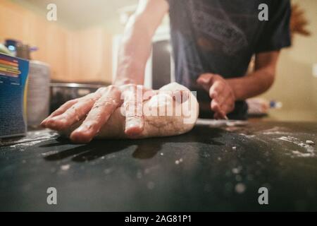 Nahaufnahme eines männlichen Kochs, mit dem der Teig geglättet wird Mehl auf den Händen Stockfoto