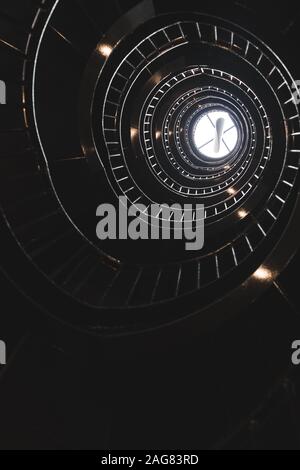 Vertikale Low-Angle-Aufnahme einer Wendeltreppe auf schwarz Hintergrund Stockfoto