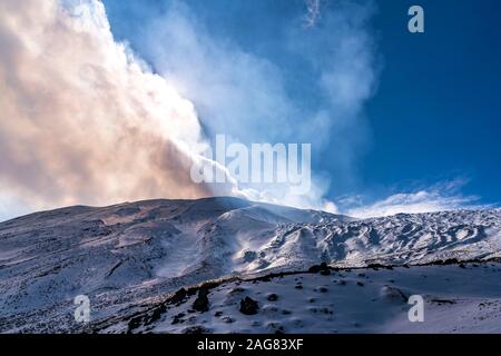 Die Sonne scheint durch die Wolken über dem schneebedeckten Vulkan Ätna, Sizilien, Italien, Europa | scheint die Sonne durch die Wolken über Schnee Stockfoto