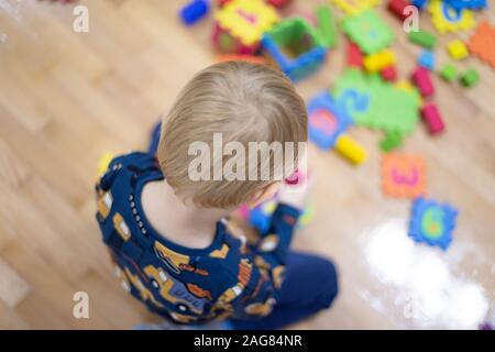 Preschooler Kind spielen mit bunten Spielzeug Bausteine. Kid spielen mit pädagogischen Holzspielzeug. Stockfoto