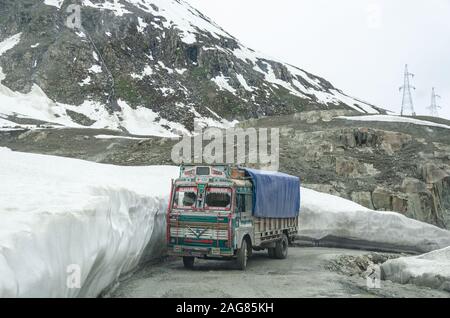 Truck manövriert im Mai eine Kurve auf dem schneebeplandeten Srinagar - LEH National Highway irgendwo in der Nähe des Starts von Zoji la Pass, Jammu und Kashmir, Indien Stockfoto