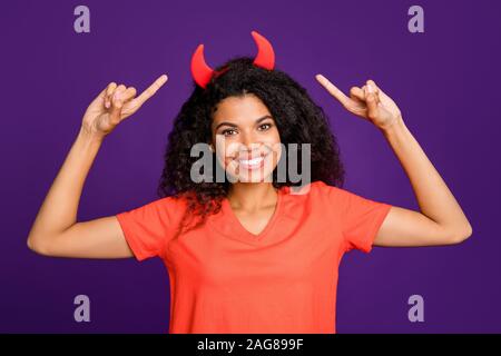 Foto fröhliche, positive niedlich hübsche süsse Freundin zeigen auf diabolische Hörner mit Ihrem Zeigefinger lächelnd toothily tragen Orange t-shirt Stockfoto