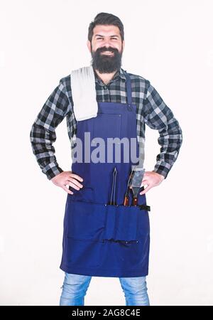 Grill im Freien. Kochen Grill. Hipster in Schürze mit Metallgegenstände, Grill. Bärtiger Mann mit Grill Greifer Werkzeuge in den Taschen. Grill kochen. Die Zubereitung von Speisen am Grill mit einem Grill. Stockfoto