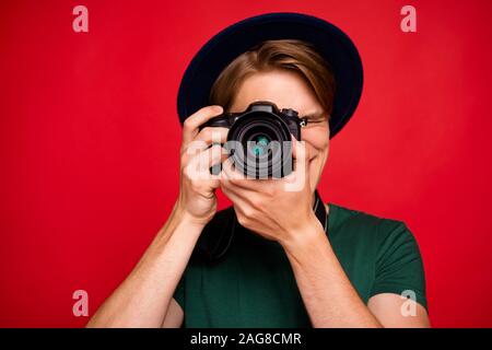 Nahaufnahme Foto fröhliche, positive guy Tourist im Ausland besuchen Ausflug haben sie Spaß dabei Foto mit seiner DLSR-Kamera tragen Blue Velvet cap Kopfbedeckungen grün Stockfoto