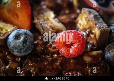 Schokolade Kuchen close-up mit wilden Früchten und Mandeln Stockfoto