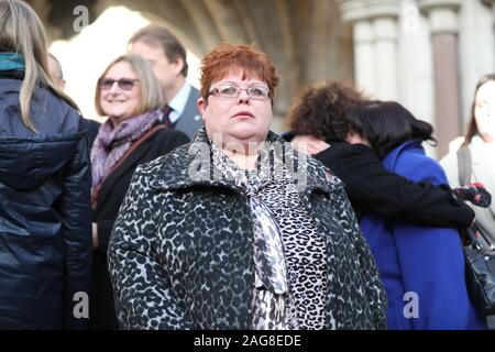 Sarah-Jane Jung (Mitte), die Tochter und der Lance Corporal Junge, ein Opfer der Hyde Park Bombardierung, außerhalb der High Court in London, nach den Familien der Opfer der ersten Phase der High Court Schäden gewonnen Anspruch gegen Verdächtige John Downey. Stockfoto