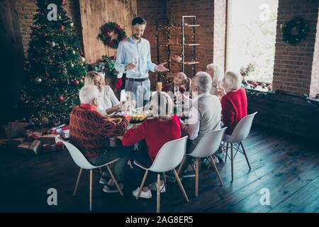 Foto der vollständigen Familie Versammlung sitzen Tisch Vater Kerl sagt x-mas Toast multi-Generation acht Mitglieder in Neujahr Weihnachten Geister Wohnzimmer Stockfoto