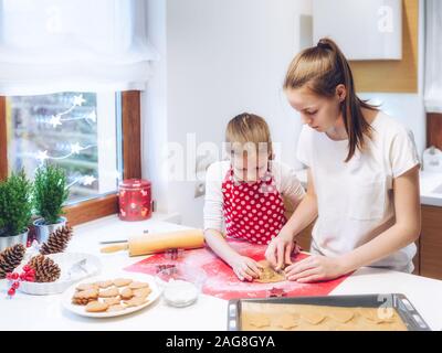 Weihnachtsbäckerei. Zwei Schwestern Lebkuchen, schneiden Cookies von Lebkuchen Teig. Festliche Essen, Kochen, kulinarisch, Weihnachten und N Stockfoto