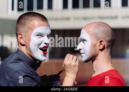 Mime macht Make-up für seinen Partner auf der Straße Stockfoto