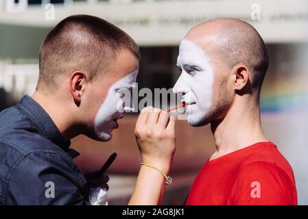 Mime macht Make-up für seinen Partner auf der Straße Stockfoto