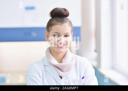 Junge weibliche männliche Wissenschaftler in einem Labor Forschung tun, mikrobiologische Analyse, Medizin. Weibliche Wissenschaftler denken, schauen und Smilling in c Stockfoto