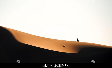 Der Mann zu Fuß auf der Sanddüne in der Wüste Lut Stockfoto