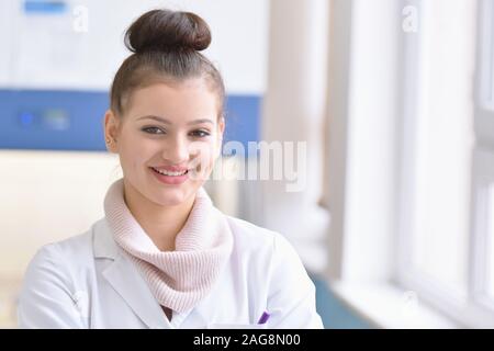 Junge weibliche männliche Wissenschaftler in einem Labor Forschung tun, mikrobiologische Analyse, Medizin. Weibliche Wissenschaftler denken, schauen und Smilling in c Stockfoto