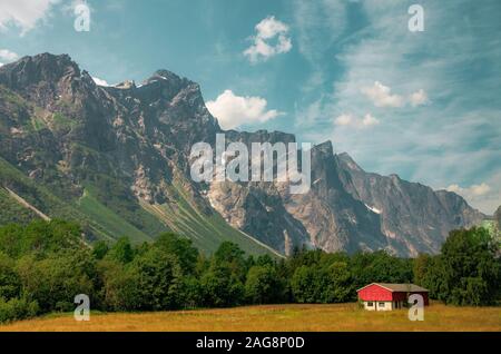 Einzelhütte in der Nähe eines Baumwaldes umgeben von wunderschönen hohen Gebirge in Norwegen Stockfoto