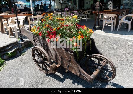 Eine Schöne Bunte Blumendarstellung in einer Großen Schubkarre in der Les Mines D'Or Bar und Restaurant in der Nähe von Morzine Portes du Soleil French Alps France Stockfoto